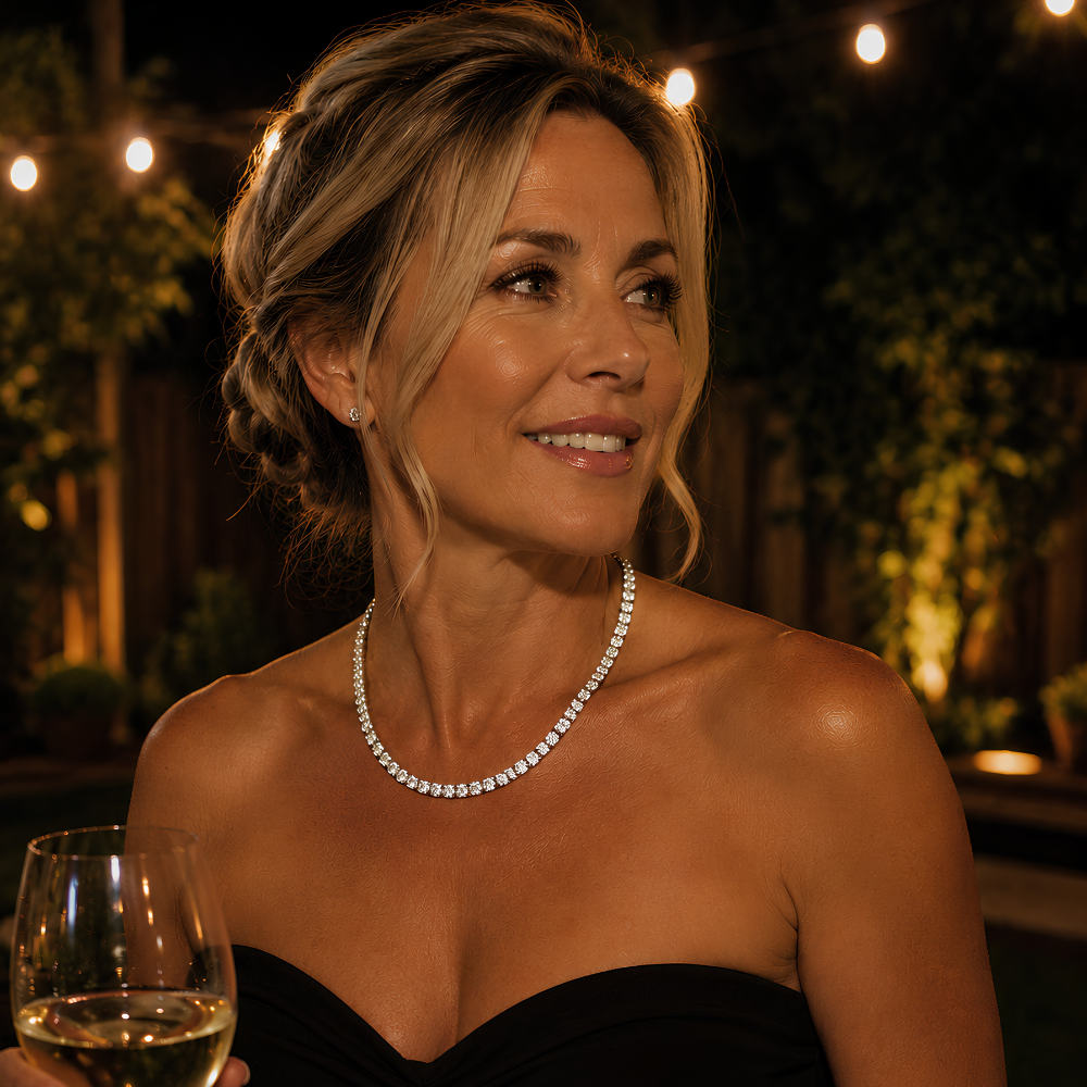 Woman in formal attire with Moissanite tennis necklace in S925 sterling silver with platinum finish, featuring a continuous row of round stones holding a glass of wine at night.