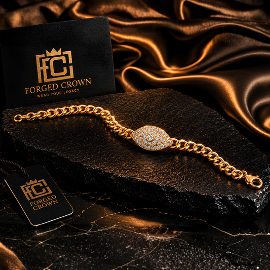 Gold finish moissanite eye bracelet with pavé center stone in S925 sterling silver, shown on textured black slab with Forged Crown packaging and satin background