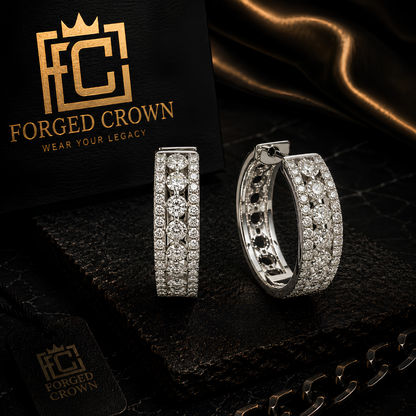 Silver hoop earrings with embedded stones on a dark surface with 'Forged Crown' branding. 20mm moissanite huggie hoops in platinum, gold, and rose gold finishes.