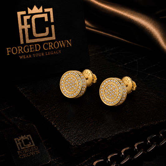 Moissanite stud earrings in S925 sterling silver with gold finish, featuring round pavé halo design shown on textured black slab with Forged Crown 
