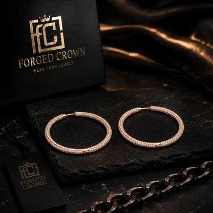 Rose gold luxury hoop earrings with pave moissanite stones displayed in premium jewelry setting on a dark surface with 'Forged Crown' branding.